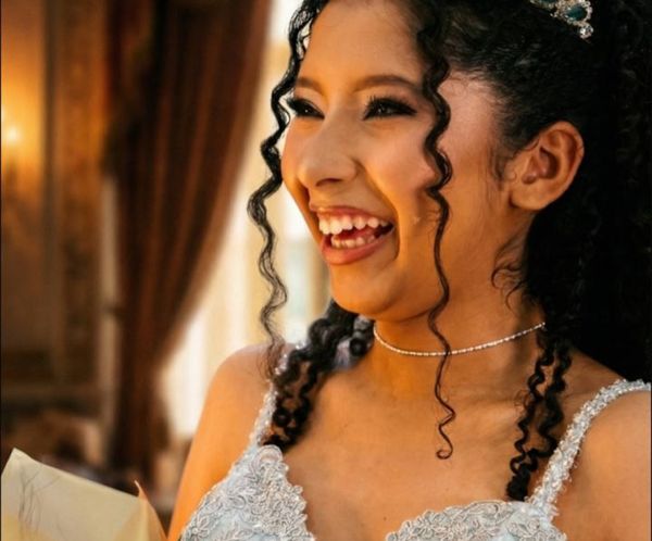 Debutante sorrindo de tiara e vestido azul claro