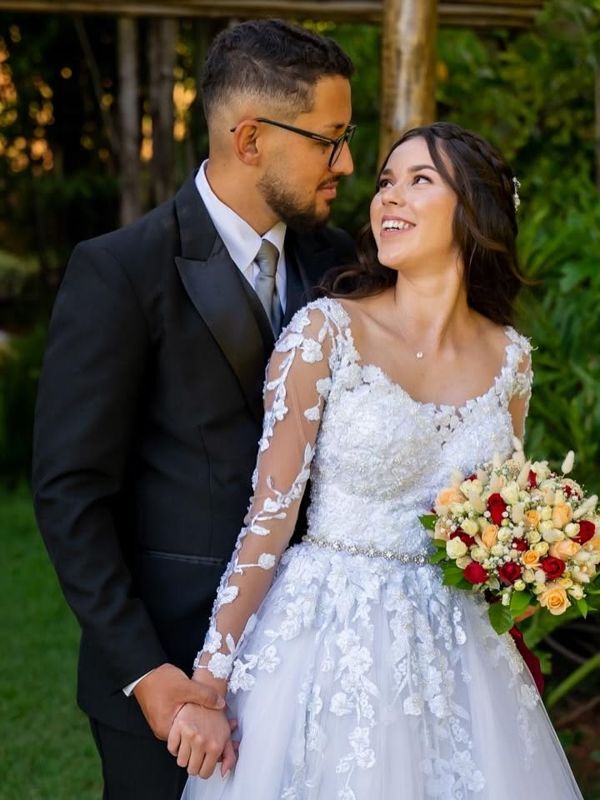 Casal de noivos no jardim, noiva olhando para o noivo